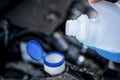 Pouring antifreeze. Filling a windshield washer tank with an antifreeze in winter cold weather. Royalty Free Stock Photo