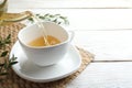 Pouring aromatic eucalyptus tea into cup on white wooden table. Space for text Royalty Free Stock Photo
