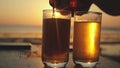 Pouring Beer in a Glass on a tropical Beach at beautiful Sunset with lens flare effects in slow motion. 1920x1080