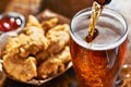 Pouring beer into mug with fried chicken tenders in background