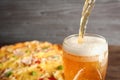 Pouring beer on pizza background