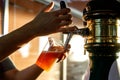 Pouring beer into a plastic glass. Sunset. Royalty Free Stock Photo