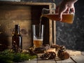 Pouring beer into a tall glass on wooden background with christmas lights Royalty Free Stock Photo