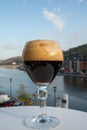 Pouring of Belgian abbey beer and tasting of cheeses made with trappist beer and fine herbs with view on Maas river in Dinant,