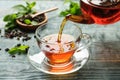 Pouring black tea into glass cup