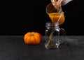 Pouring bright orange mocktail made of pumpkin