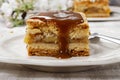 Pouring caramel sauce on piece of apple pie