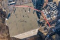 Pouring cement on the floors of residential multi-story building under construction using a concrete pump truck with high boom to Royalty Free Stock Photo