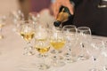 Pouring champagne in flutes standing on table Royalty Free Stock Photo