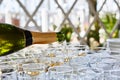 Pouring champagne in flutes standing on table Royalty Free Stock Photo