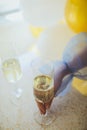 Pouring champagne in flutes standing on table Royalty Free Stock Photo