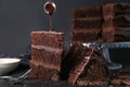 Pouring of chocolate onto piece of tasty cake on table