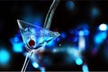 Pouring martini cocktail on dark background Royalty Free Stock Photo
