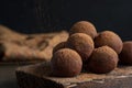 Pouring cocoa powder on enegry balls. Homemade Healthy vegan Raw Energy truffle Balls with on wooden cutting board.