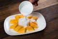 Pouring cocunut milk onto mango sticky rice, a traditional thailand dessert Royalty Free Stock Photo