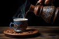 Pouring coffee into a cup on a wooden table. Black background, Pouring coffee from turkish coffee pot into decorated coffee cup on Royalty Free Stock Photo