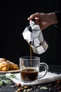 Pouring coffee from an italian percolator, shot in low key