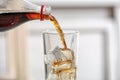 Pouring cola from bottle into glass on blurred background Royalty Free Stock Photo