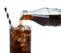 Pouring cola from bottle into glass with ice cubes on white background, closeup. Refreshing soda water Royalty Free Stock Photo