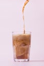 Pouring cola from bottle into glass with splashing Royalty Free Stock Photo