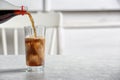 Pouring cola from bottle into glass on table. Royalty Free Stock Photo