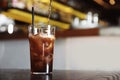 Pouring cola into glass with ice cubes on table indoors. Royalty Free Stock Photo