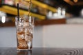 Pouring cola into glass with ice cubes on table. Space for text Royalty Free Stock Photo