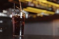 Pouring cola into glass with ice cubes on table. Space for text Royalty Free Stock Photo