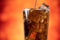 Pouring Cola with ice cubes close-up. Cola with Ice and bubbles in glass. Royalty Free Stock Photo