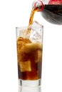 Pouring Cola to glass with ice cubes isolated on white Royalty Free Stock Photo
