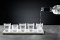 Pouring cold vodka into shot glass isolated on dark background. Selective focus Royalty Free Stock Photo