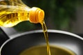 Pouring cooking oil from bottle into frying pan Royalty Free Stock Photo