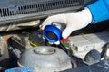 Pouring coolant Service of cars. Pouring antifreeze. Mechanic fills the coolant G12 to tank in the engine