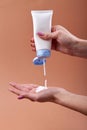 Pouring cream from the tube on a hand.