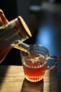 Pouring delicious tea into glass cup on wooden table, closeup Royalty Free Stock Photo