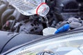 Pouring distilled water ecological alternative to washing fluid to washer tank in car, detail on clear plastic bottle