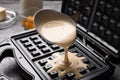 Pouring dough onto Belgian waffle maker