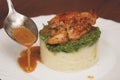 Pouring Dressing Sauce over a Delicious Mashed Potatoe with Chicken Meat. Food Photography.