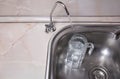 Pouring drinkable water into glass jug from water filter. Closeup of sink and faucet. Filtered water Royalty Free Stock Photo