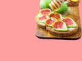 Pouring drizzling honey on sourdough toast with cream cheese topped with fresh ripe figs peaches Royalty Free Stock Photo