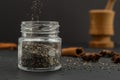 Pouring dry chia seeds in glass jar with unfocused objects on background. Copy space. Royalty Free Stock Photo