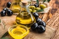 Pouring extra virgin olive oil in a glass bowl and olives