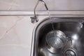 Pouring filtered water into pot from water filter. Closeup of sink and faucet. Drinkable water Royalty Free Stock Photo