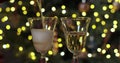 Pouring a flute of fizzy effervescent champagne with sparkling bokeh of twinkling colorful party lights on the blurry Royalty Free Stock Photo