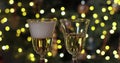 Pouring a flute of fizzy effervescent champagne with sparkling bokeh of twinkling colorful party lights on the blurry Royalty Free Stock Photo