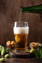 Pouring fresh beer from bottle into beer glass Royalty Free Stock Photo