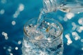 Pouring Fresh Drinking Water into Glass on Blue Background Royalty Free Stock Photo