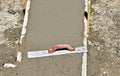 Trowellng fresh concrete on a garage foundation with a trowel left  on the surface Royalty Free Stock Photo
