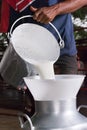 Pouring fresh and delicious milk from the bucket into the pitcher Royalty Free Stock Photo