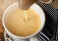 Pouring fresh morning coffee with espresso machine and sunlight and raw aroma beans Royalty Free Stock Photo